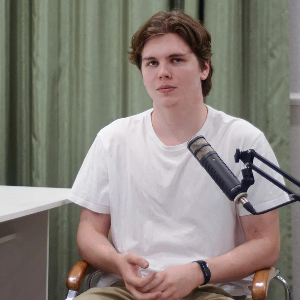 Ivan Ilin seated beside a studio microphone